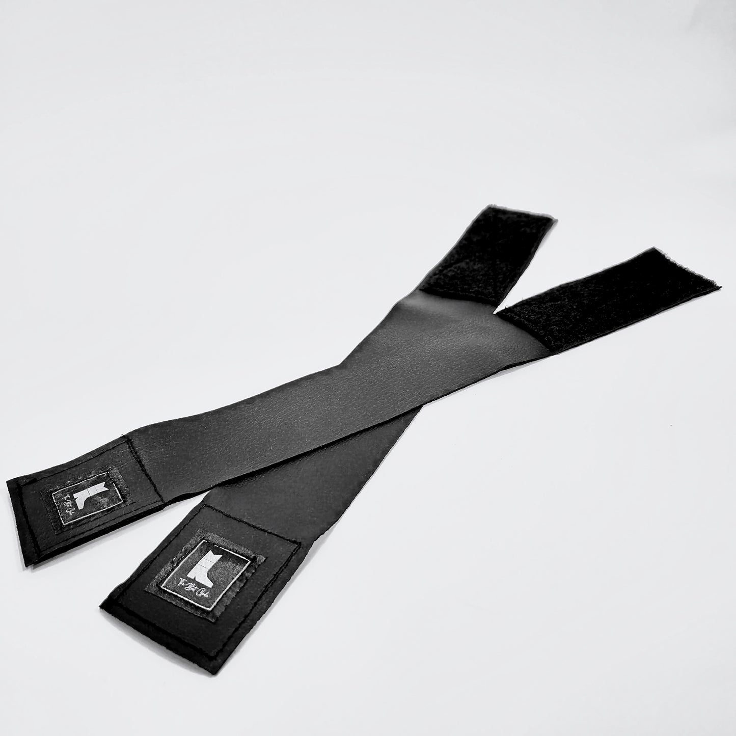 Two black boot girdle straps with adjustable Velcro closure,designed to keep your boot shafts hidden in any style of pants